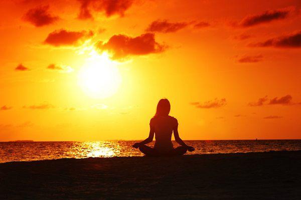 ヨガをする女性と夕日