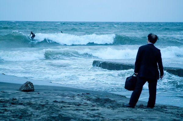 海にたたずむサラリーマン
