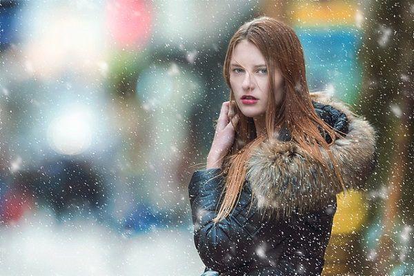 粉雪とフードの女性