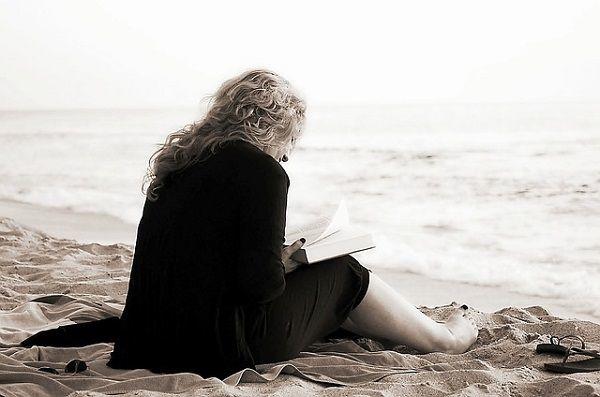 海辺で本を読む女性